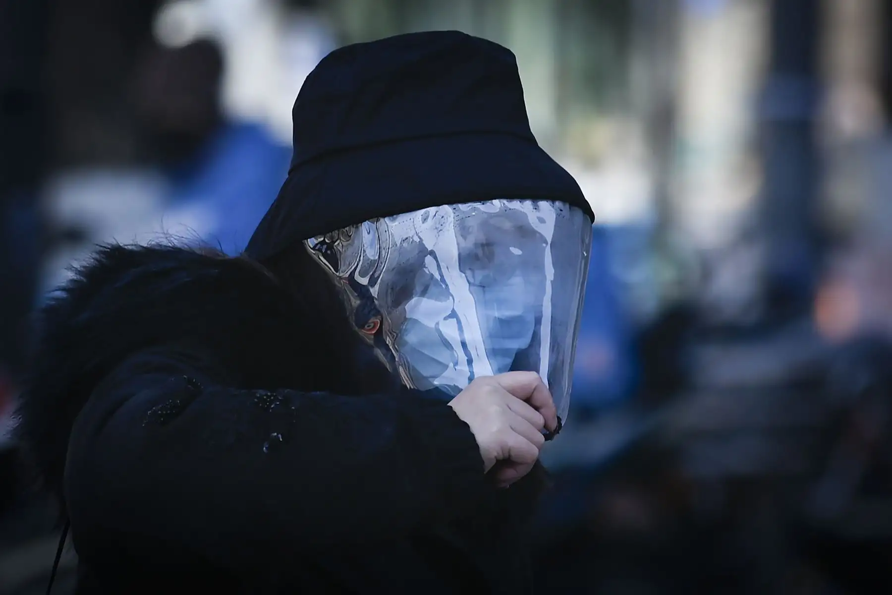 Una mujer con una máscara facial camina por una calle en Beijing. Foto: AFP