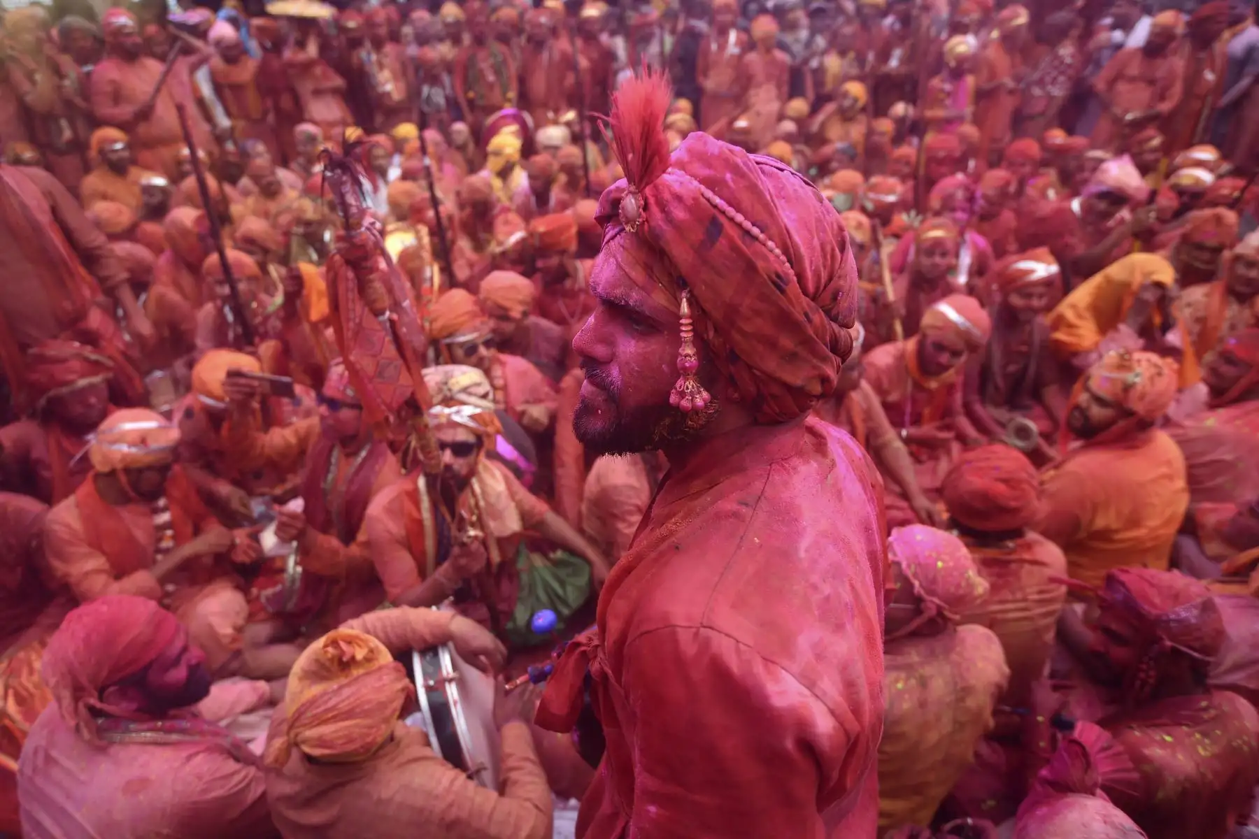 Devotos hindúes manchados con polvo de color llevan las imágenes del templo Kashi Vishwanath durante el festival de colores de primavera. Foto: AFP