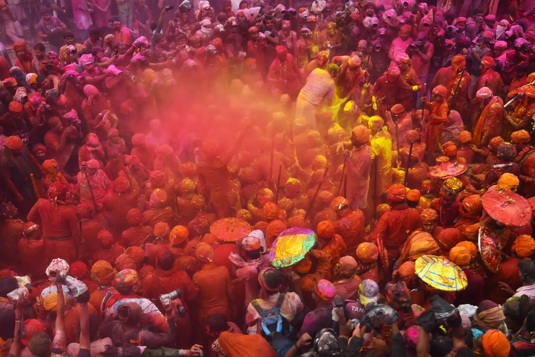 Devotos hindúes manchados con polvo de color llevan las imágenes del templo Kashi Vishwanath durante el festival de colores de primavera. Foto: AFP