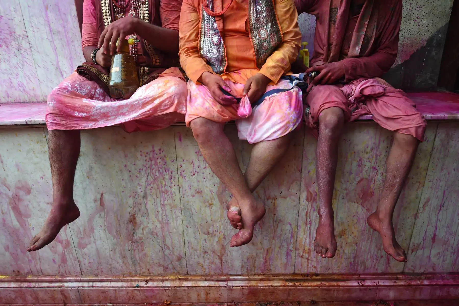 Devotos hindúes se sientan en la columna de un templo mientras celebran Holi, el festival de primavera de colores. Foto: AFP