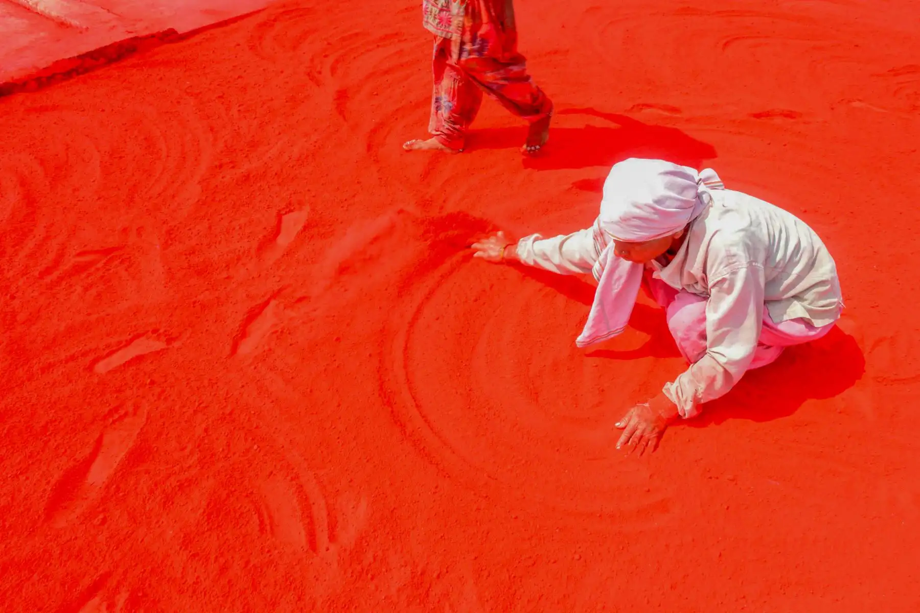 Trabajadores esparcen polvo de color rojo 