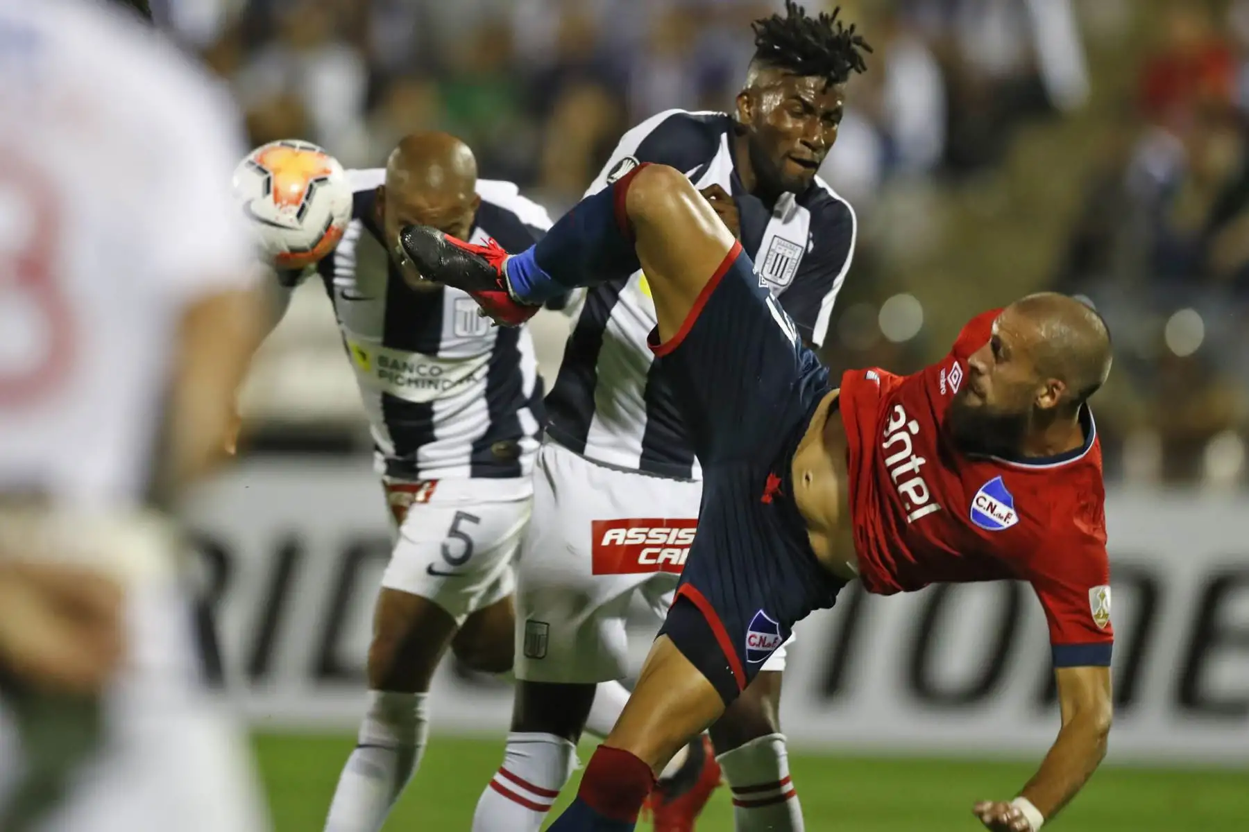 Los futbolistas Alberto Rodriguez y Carlos Ascues  de Alianza Lima disputan el balón con un jugador del Nacional de Uruguay, durante el partido por la Copa Libertadores 2020 en el estadio Alejandro Villanueva .
Foto:ANDINA/Carlos Lezama