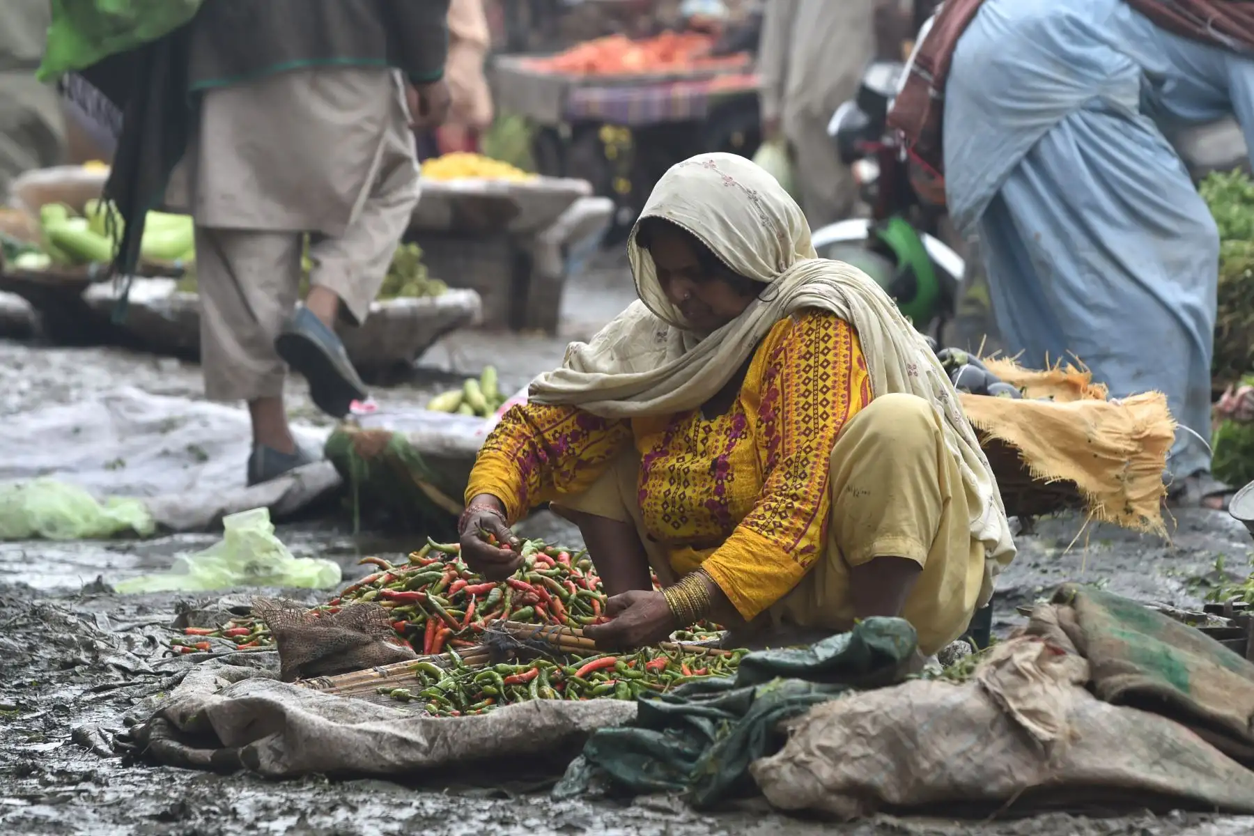 Una mujer espera clientes en un mercado de verduras antes del Día Internacional de la Mujer.
Foto: AFP