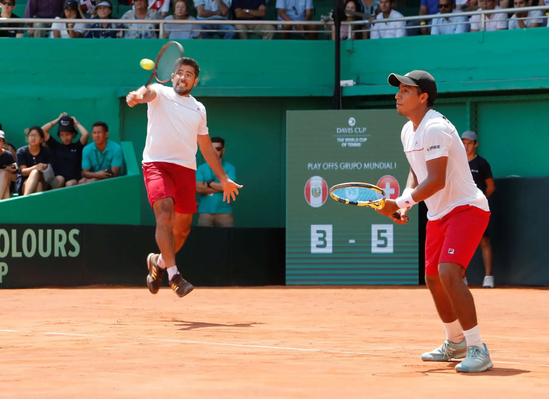 Los tenistas peruanos Sergio Galdos (i) y Jorge Panta (d) en acción contra la dupla suiza Sandro Ehrat y Luca Margaroli, durante un partido por los Play Off del Grupo mundial I de la Copa Davis entre Perú y Suiza este sábado, en el estadio Hermanos Buse de la ciudad de Lima (Perú). EFE