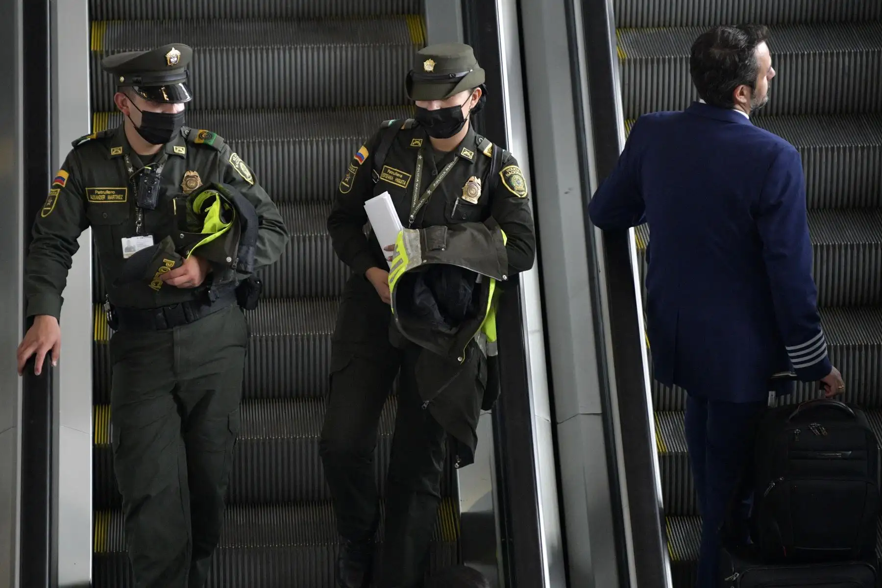 Dos miembros de la policía usan mascarillas protectoras como medida preventiva contra la propagación del nuevo Coronavirus, COVID-19, en el aeropuerto El Dorado de Bogotá. Foto: AFP