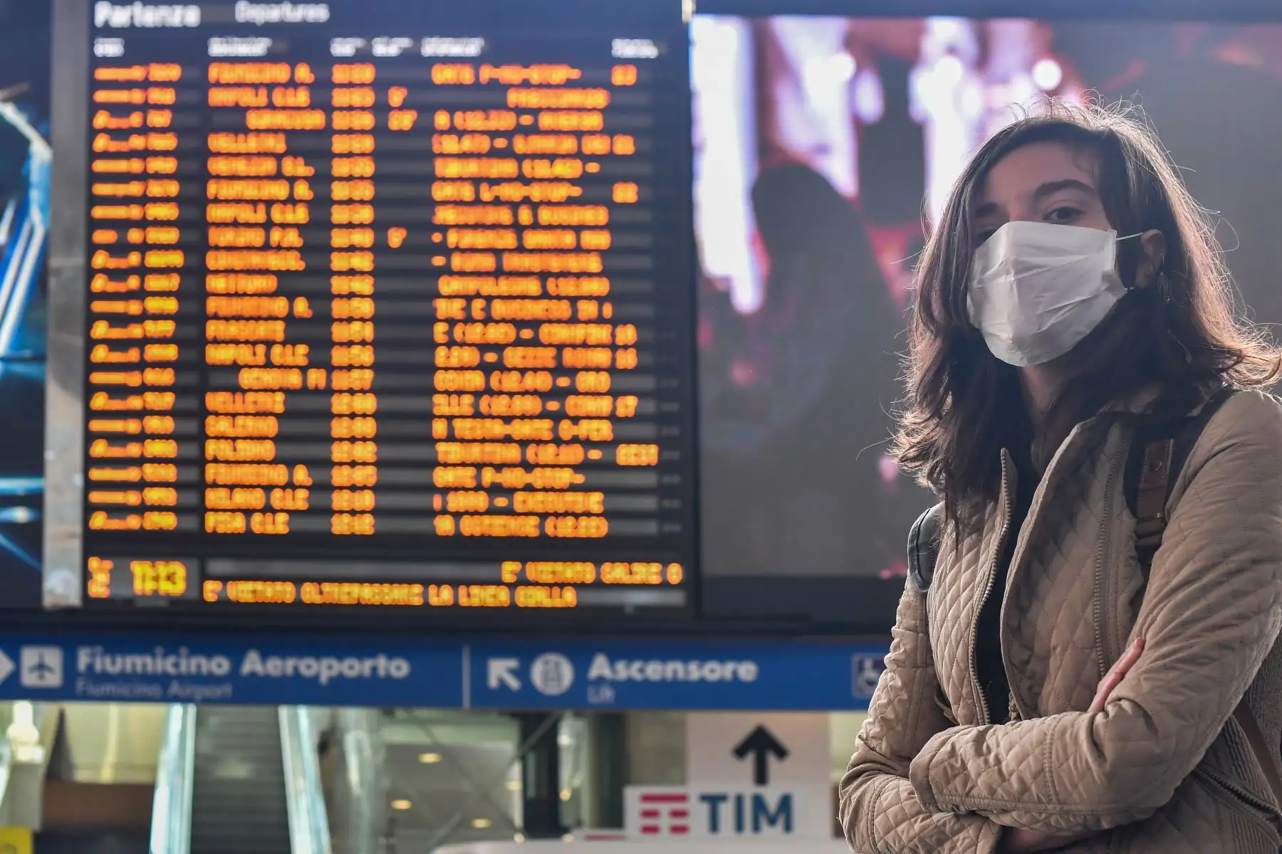 Una mujer que lleva una máscara respiratoria espera un horario en la estación de trenes de Termini en Roma. Foto: AFP