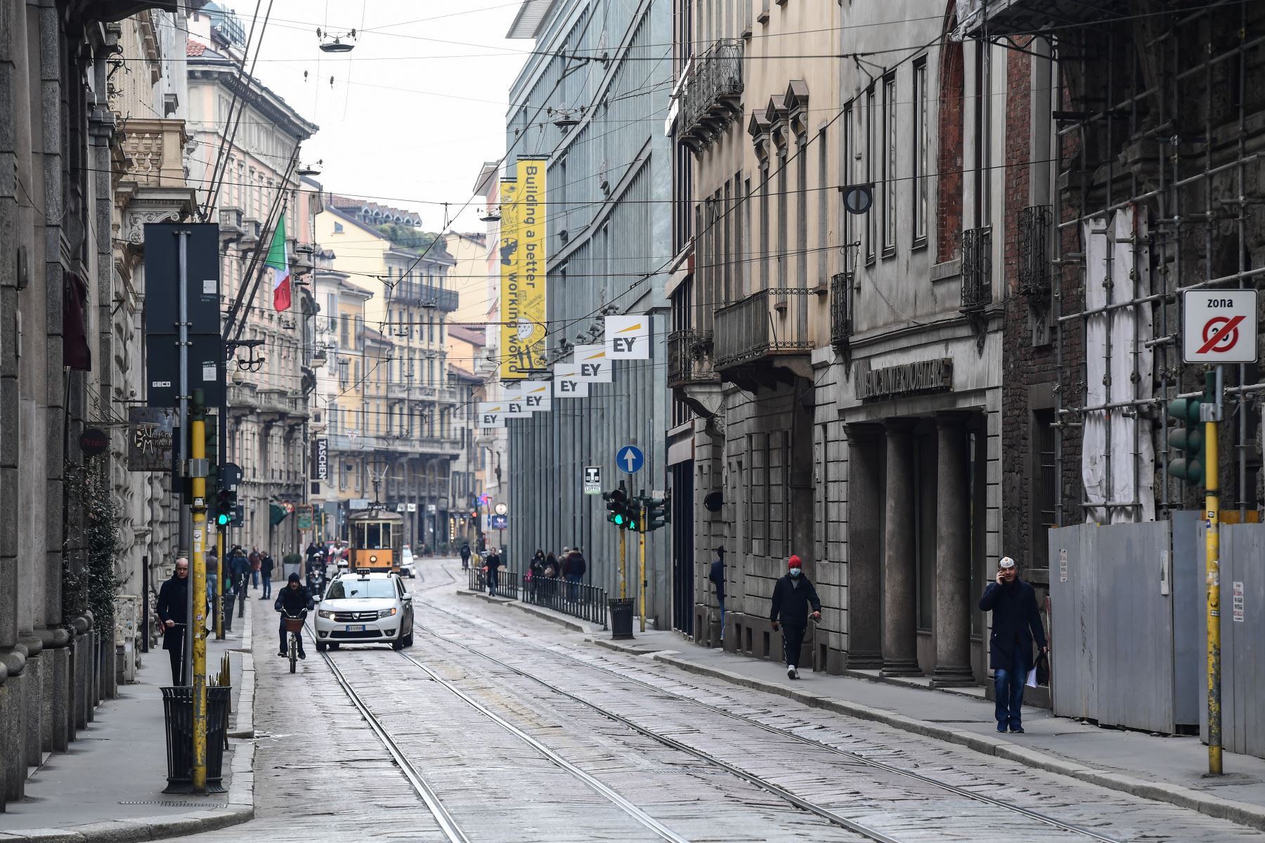Los peatones, algunos con una máscara respiratoria, caminan por una calle en el centro de Milán. Italia impuso restricciones nacionales sin precedentes a sus 60 millones de personas. Foto: AFP