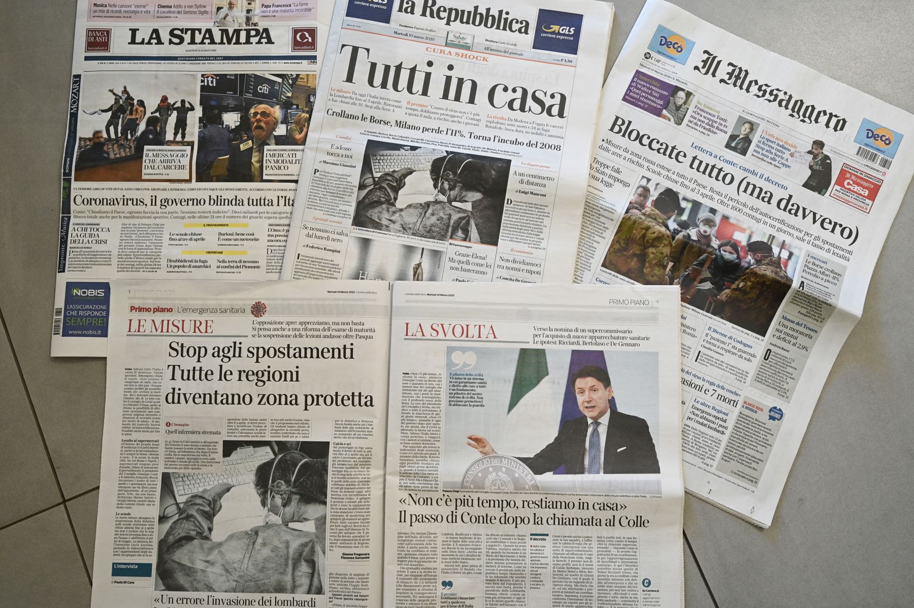 En la portadas se lee  "Coronavirus, el gobierno bloquea toda Italia", "Todos en casa", "Realmente todo bloqueado" se muestran en Roma en 10 de marzo de 2020. Foto: AFP
