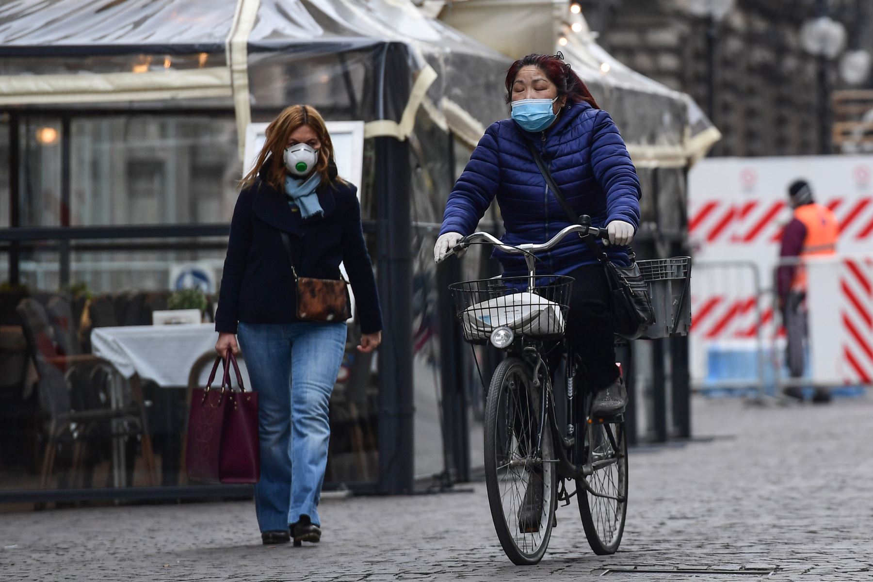 Una mujer que llevaba una máscara respiratoria monta una bicicleta en el centro de Milán. Foto: AFP