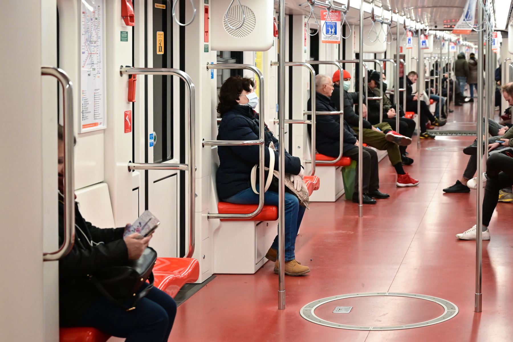 Pasajeros con una máscara respiratoria, viajan en el metro de Milán. Foto: AFP