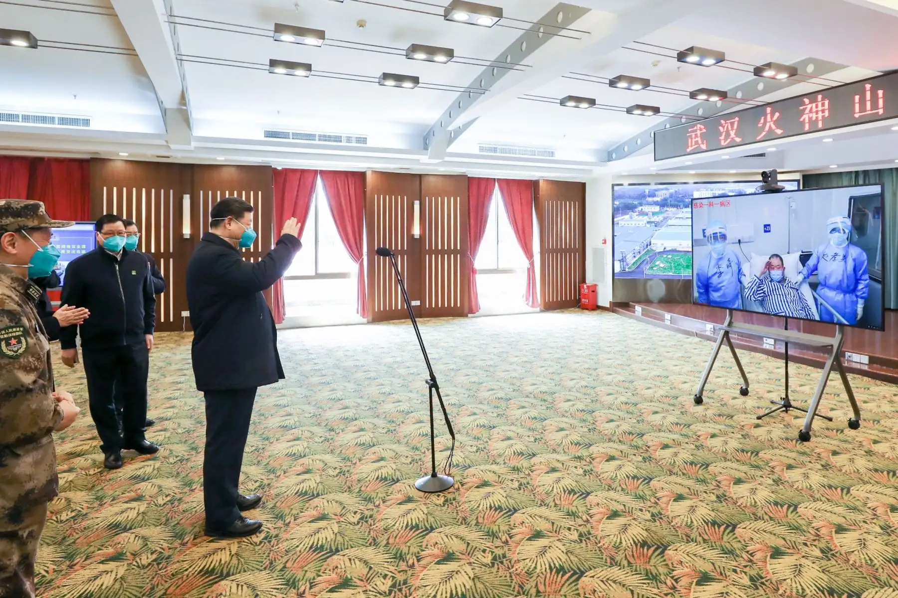 El presidente chino Xi Jinping usa una máscara mientras conversa con un paciente con coronavirus y personal médico a través de un enlace de video en China. Foto: AFP