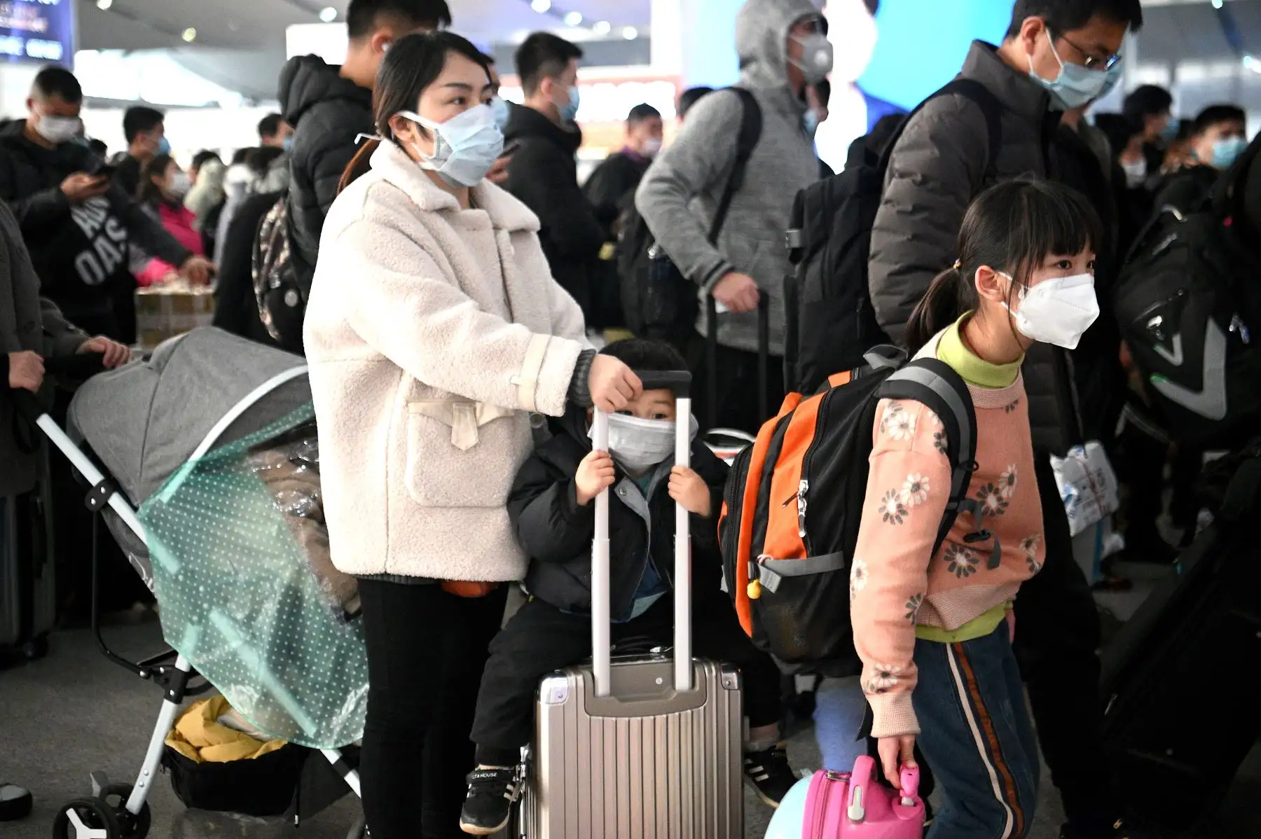 Pasajeros con máscaras faciales esperan sus trenes en la estación ferroviaria de Changsha en China. Foto: AFP