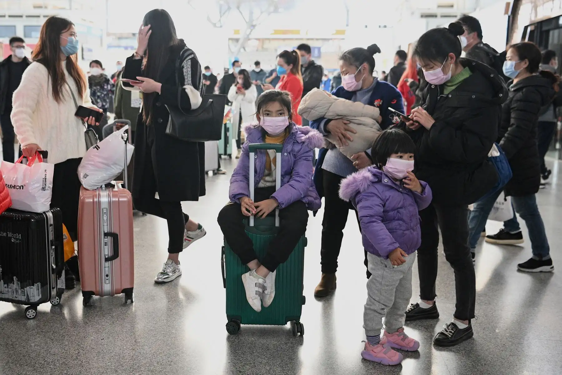 Pasajeros con máscaras faciales esperan sus trenes en la estación ferroviaria de Changsha en China. Foto: AFP