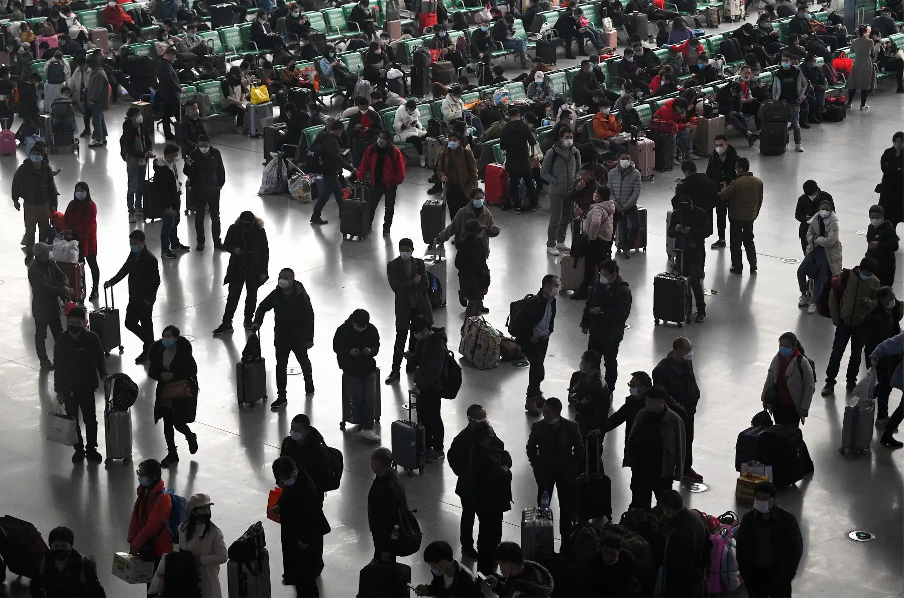 Pasajeros con máscaras faciales esperan sus trenes en la estación ferroviaria de Changsha en China. Foto: AFP
