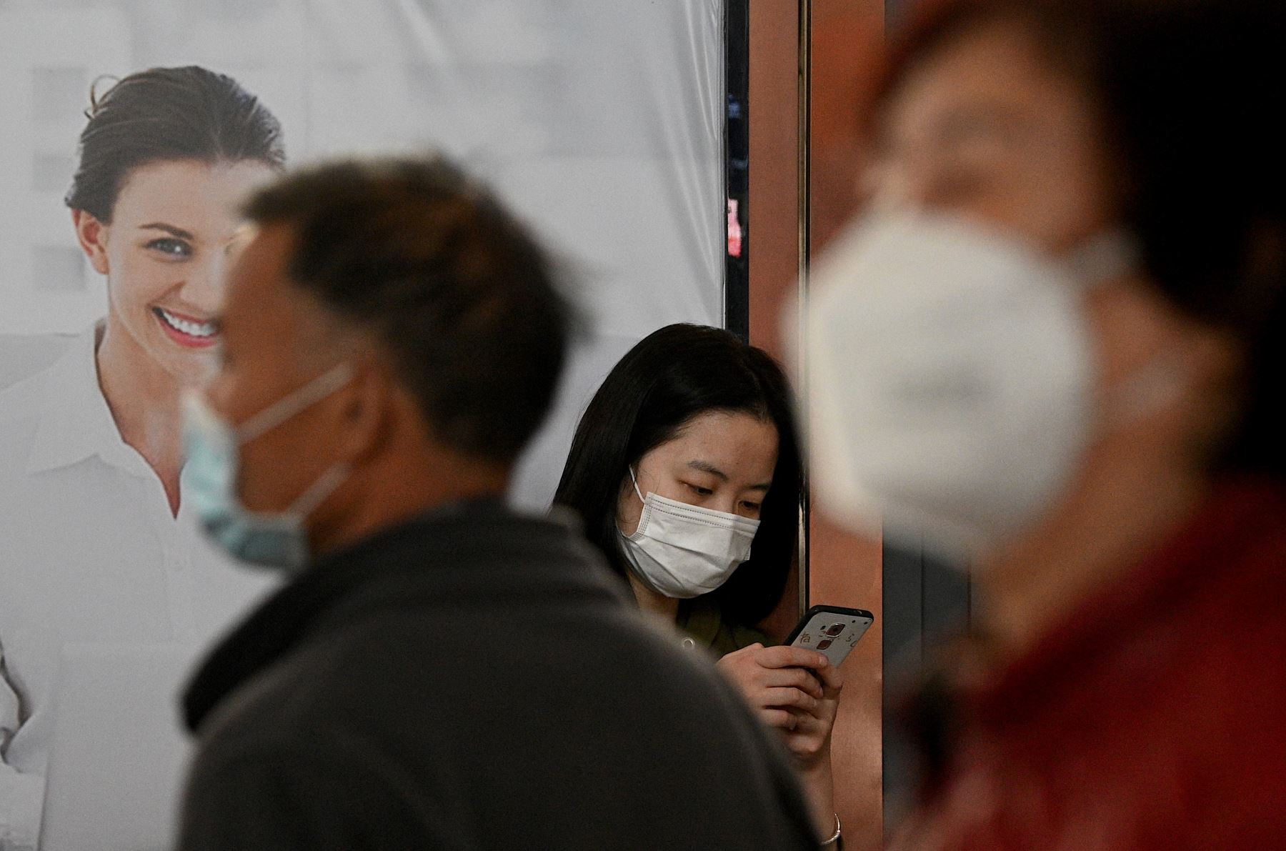 Pasajeros con máscaras faciales esperan sus trenes en la estación ferroviaria de Changsha en China. Foto: AFP