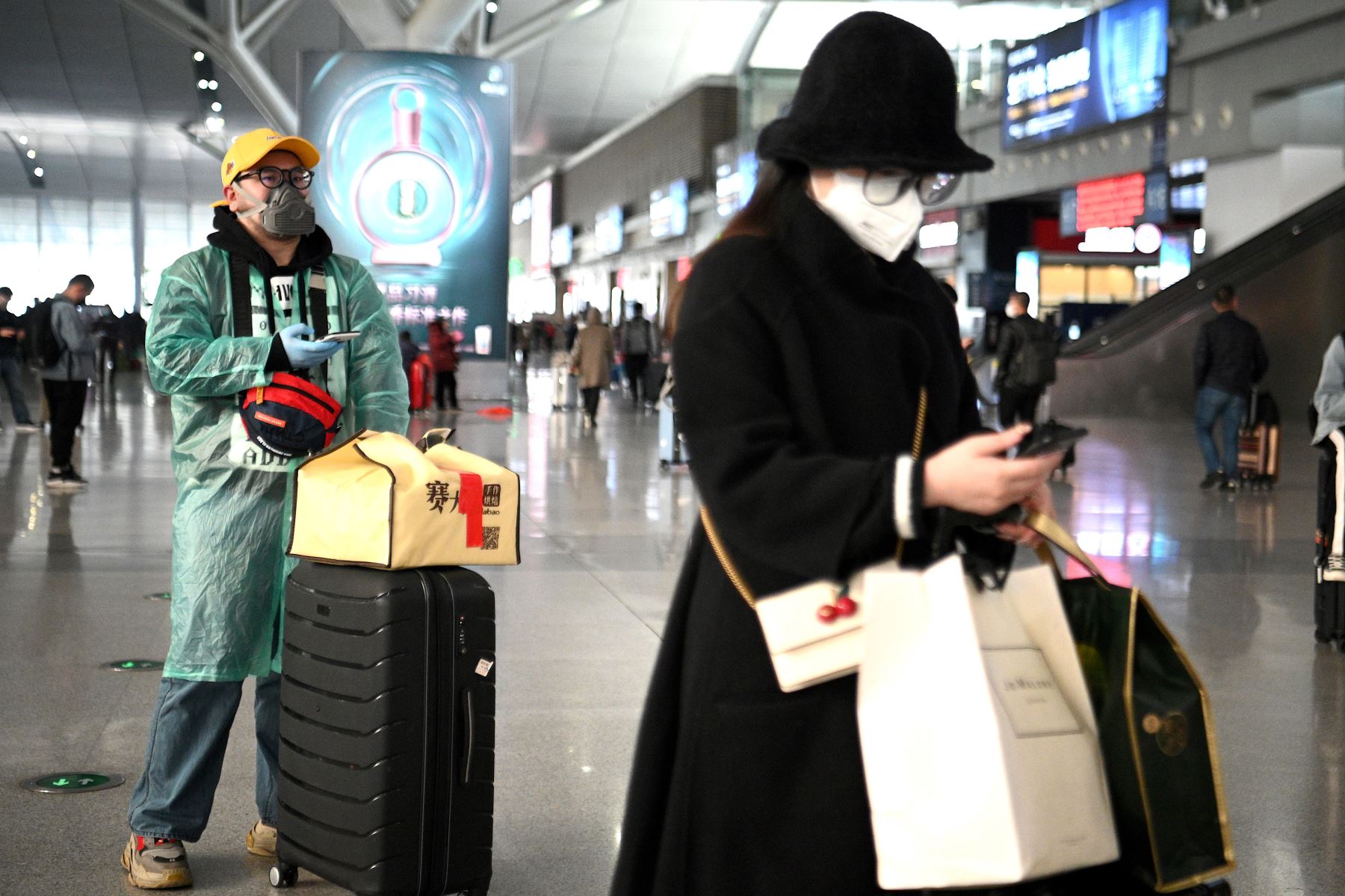 Pasajeros con máscaras faciales esperan sus trenes en la estación ferroviaria de Changsha en China. Foto: AFP