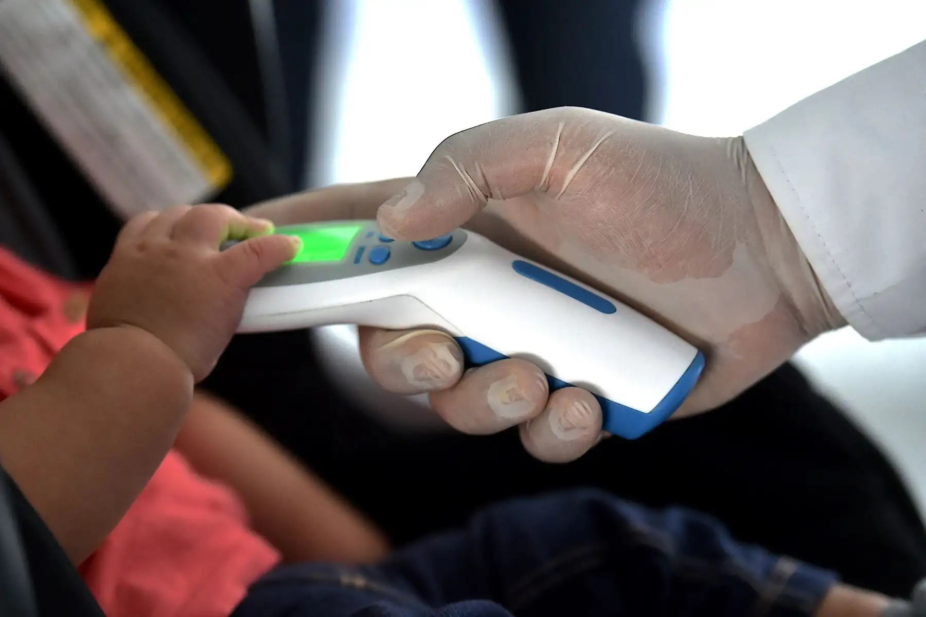 Un miembro de seguridad verifica la temperatura de un pasajero como medida preventiva contra la propagación del nuevo Coronavirus, COVID-19, en el aeropuerto internacional Bonilla Aragón en Palmira, Colombia. Foto: AFP