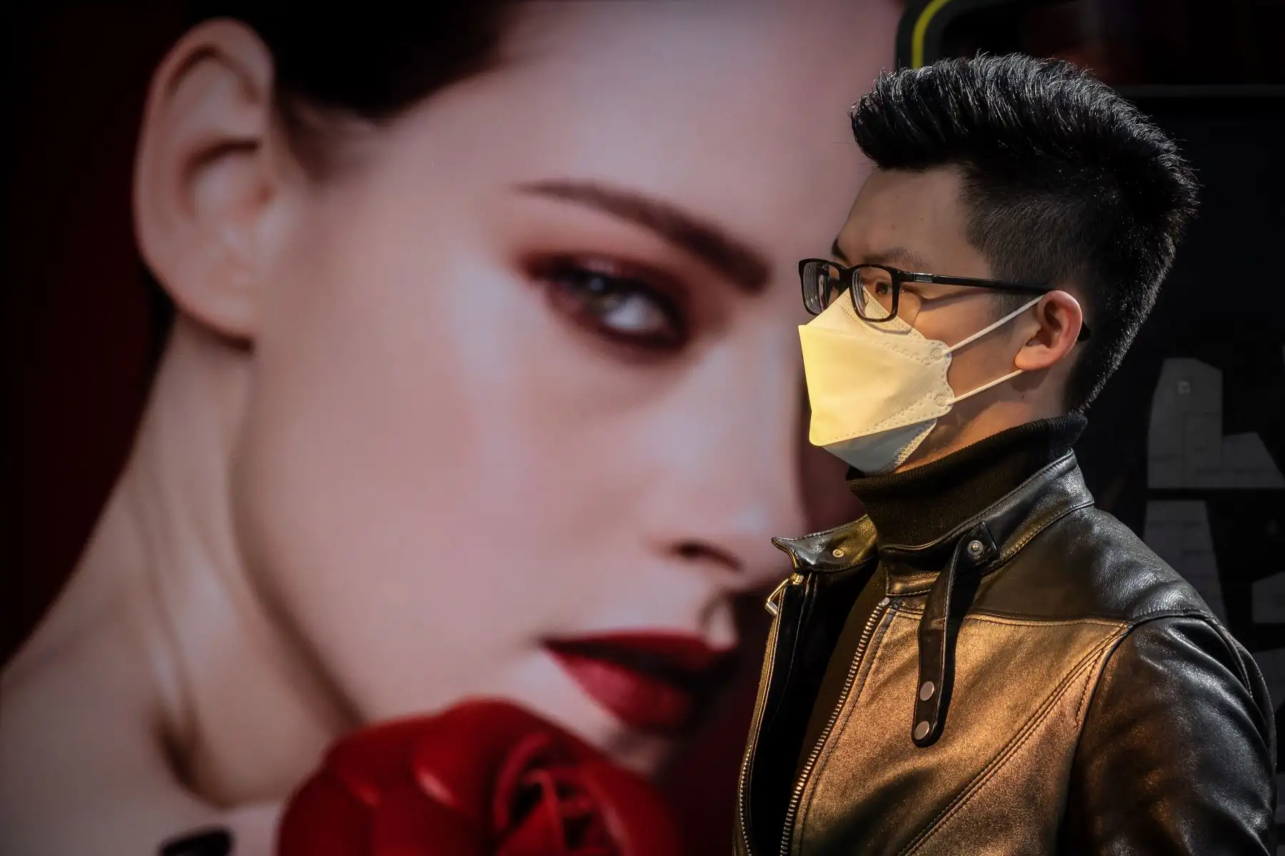 Un hombre con una máscara facial como medida preventiva contra el coronavirus COVID-19 camina fuera de un centro comercial en Beijing. Foto: AFP