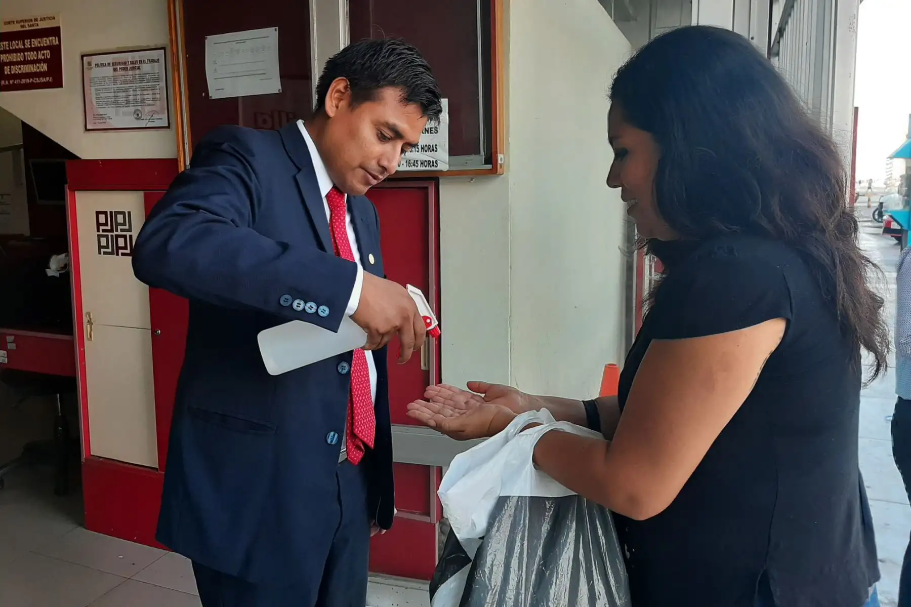 En cada una de las puertas de acceso de la Corte del Santa, personal se encarga de echar alcohol en las manos de los ciudadanos.