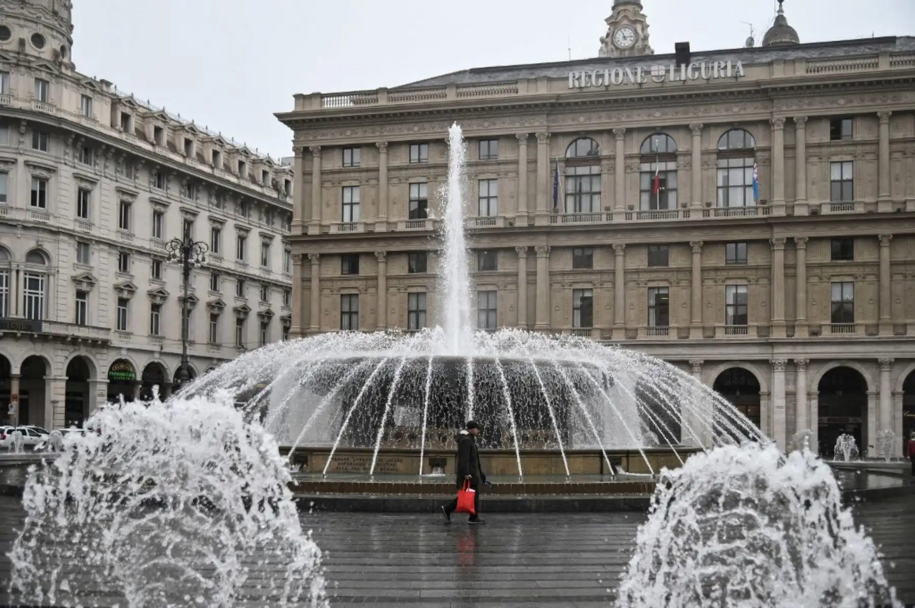 Una persona camina por la Piazza Raffaele de Ferrari en Génova luego de que Italia cerró todas las tiendas, excepto las farmacias y las tiendas de alimentos. Foto: AFP