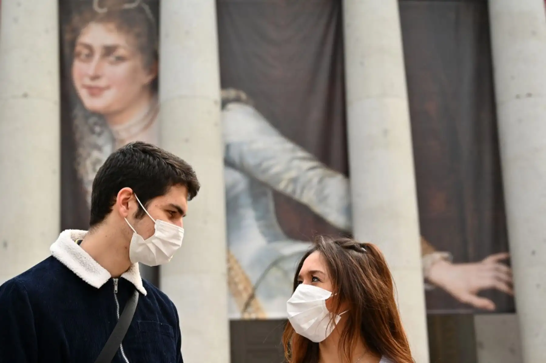 Una pareja con máscaras protectoras está parada frente al museo El Prado en Madrid, después de que todos los museos estatales de Madrid fueron cerrados al público debido al brote de coronavirus.Foto: AFP