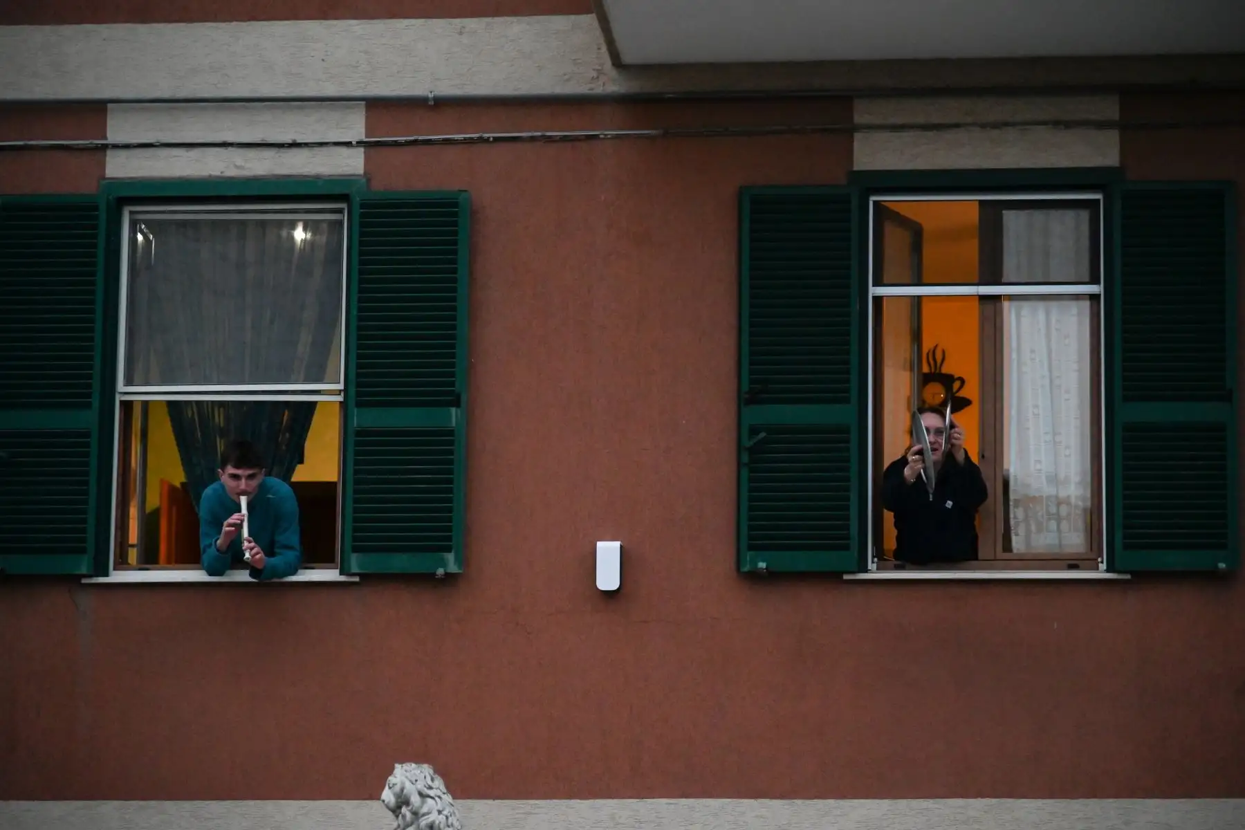 La gente toca el himno nacional italiano con instrumentos musicales y tapas de ollas desde la ventana de su casa durante una multitud de música llamada "¡Mira desde la ventana, Roma mía!" (Affacciati alla Finestra, Roma Mia!) Destinado a animar el silencio de la ciudad durante el nuevo encierro de coronavirus, en Roma.
Foto: AFP