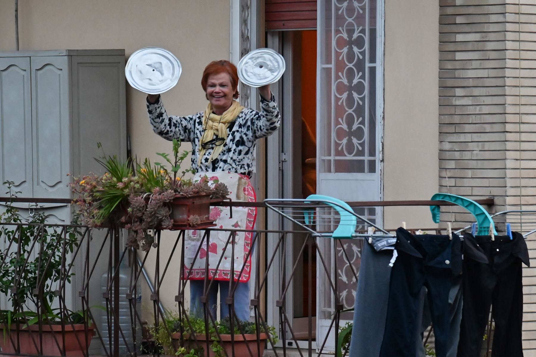 Un residente usa tapas de olla para tocar platillos mientras ella participa en un flash mob de música llamado "¡Mira desde la ventana, Roma mía!" (Affacciati alla Finestra, Roma Mia!) Destinado a animar el silencio de la ciudad durante el nuevo bloqueo de coronavirus, desde su balcón en Roma.
Foto: AFP