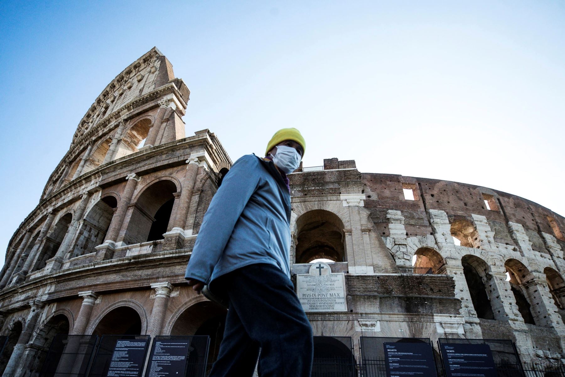 Un turista se protege con una mascarilla mientras transita por Coliseo Romano, en Italia. Foto: EFE