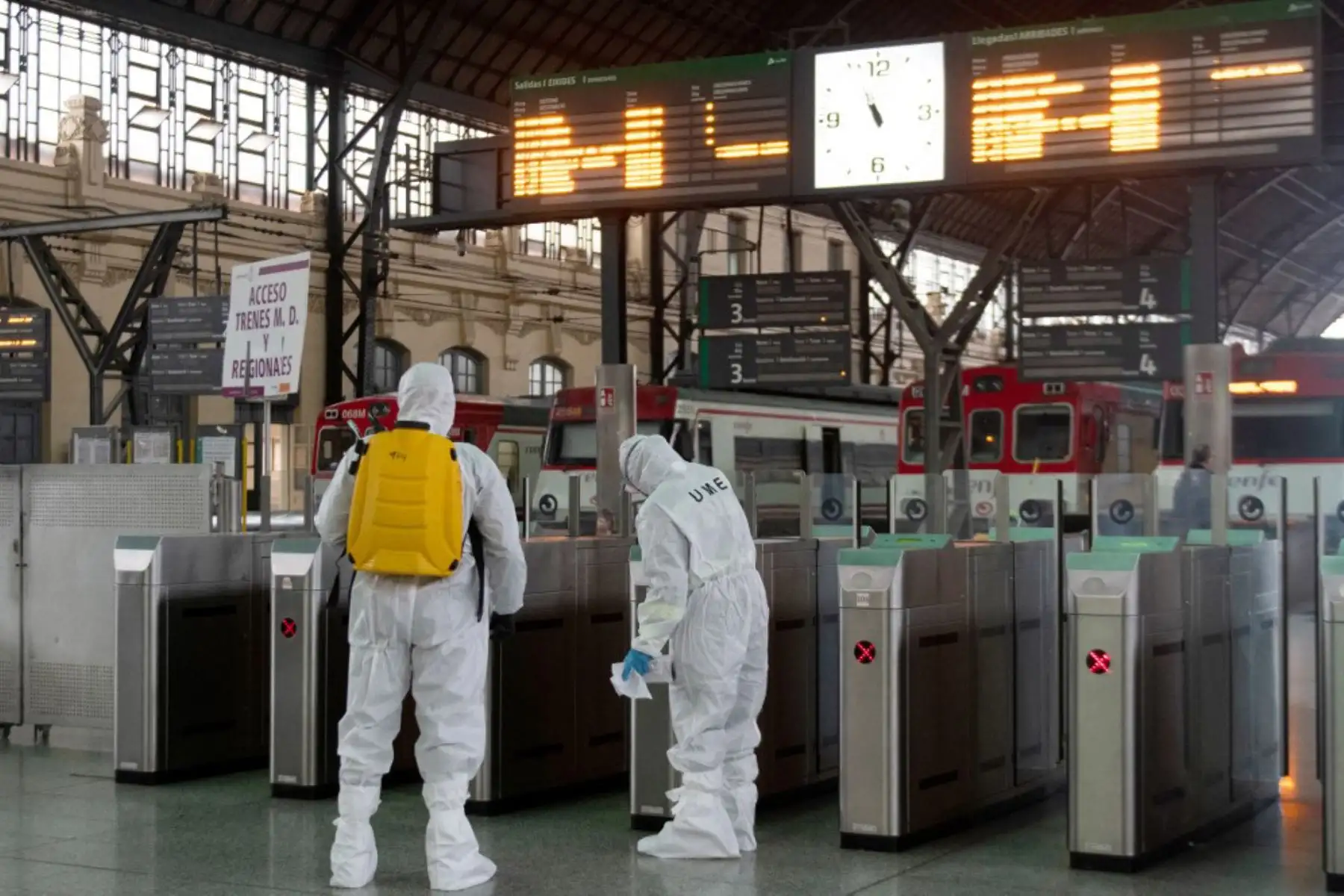 Miembros de la Unidad de Emergencias Militares llevan a cabo una desinfección general en la estación de tren en Valencia. Foto: AFP