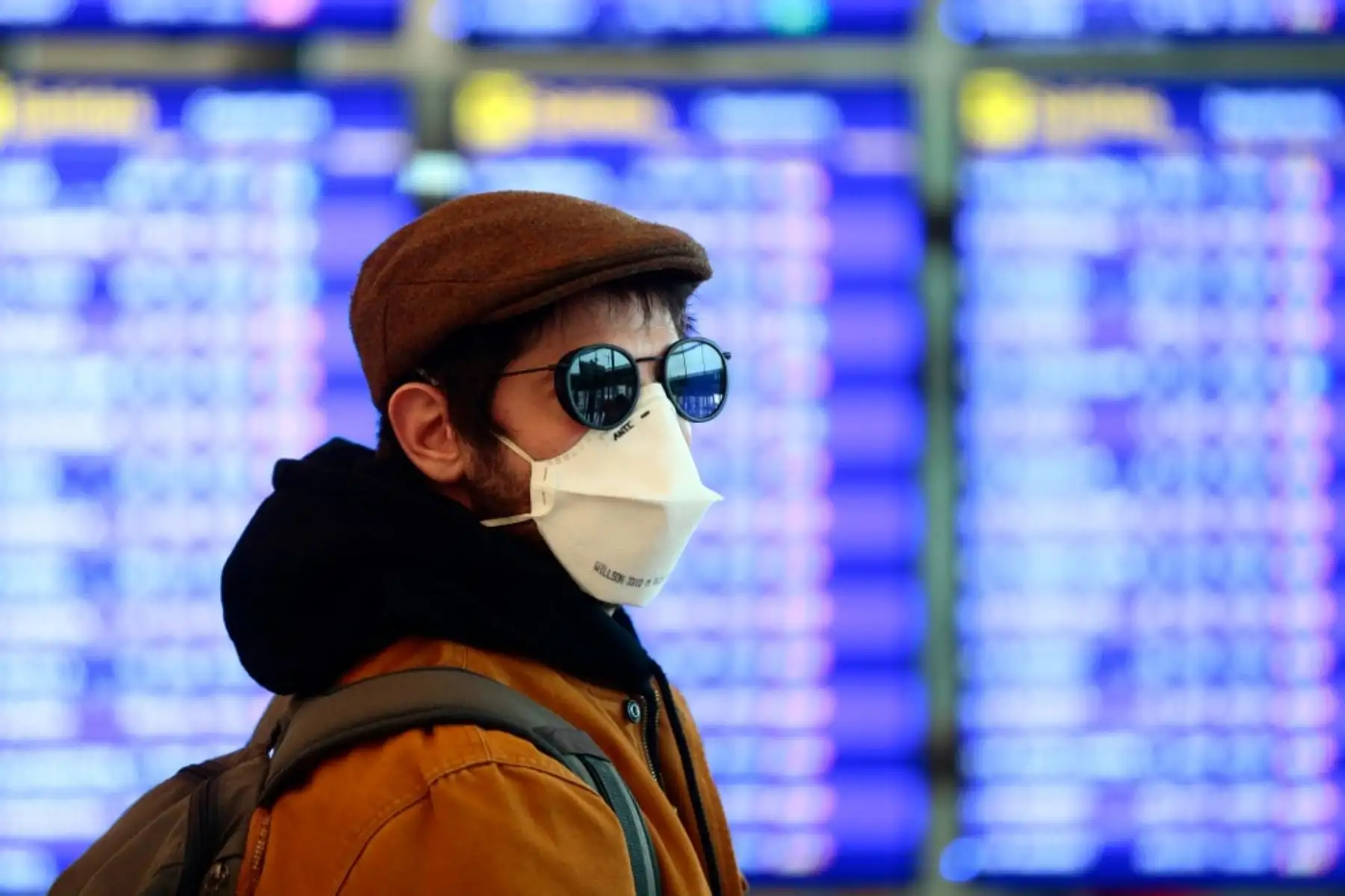 Una persona con una máscara protectora camina en el aeropuerto de Barcelona. Foto: AFP