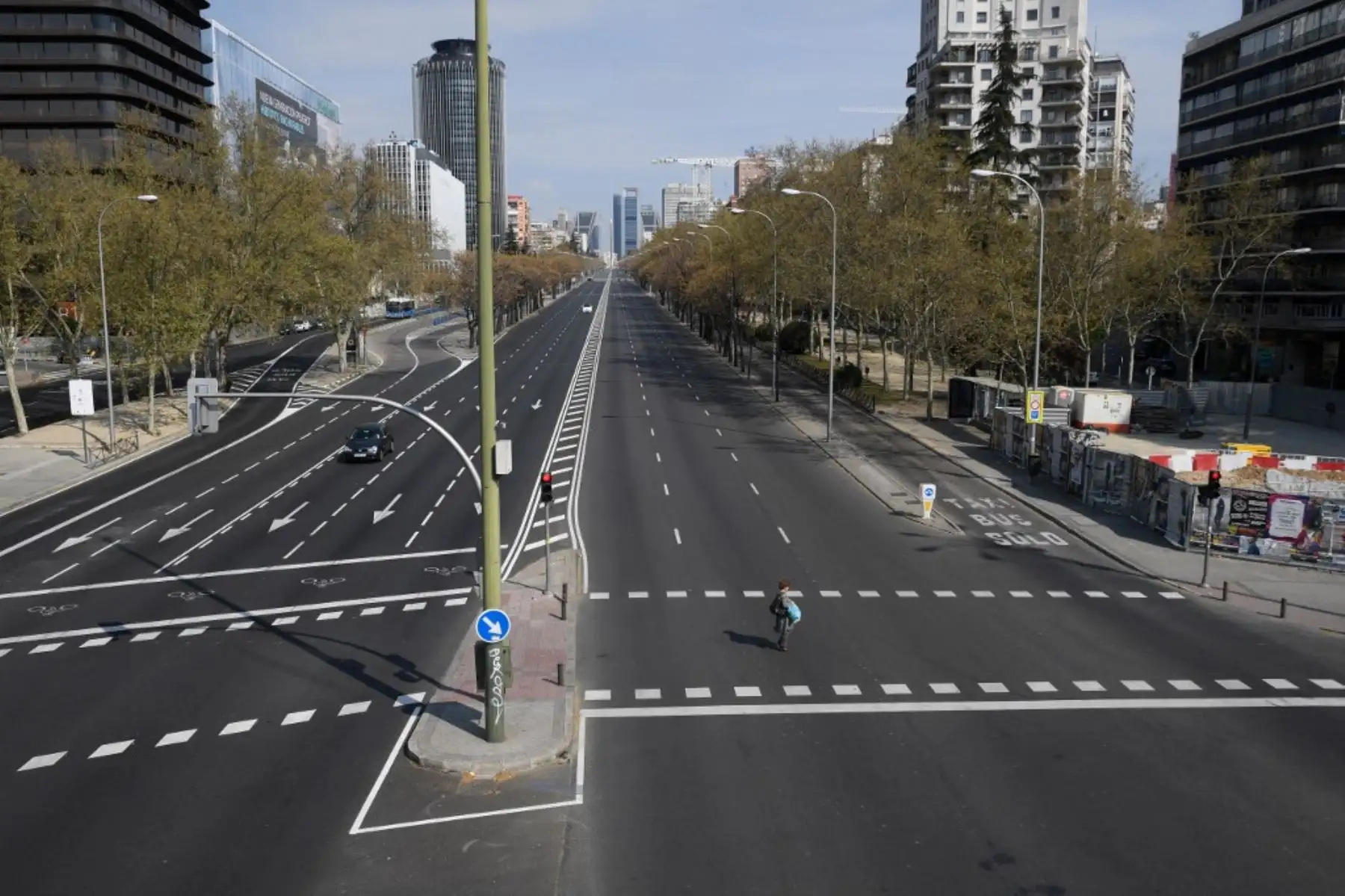Una mujer cruza la concurrida avenida La Castellana en Madrid. Foto: AFP