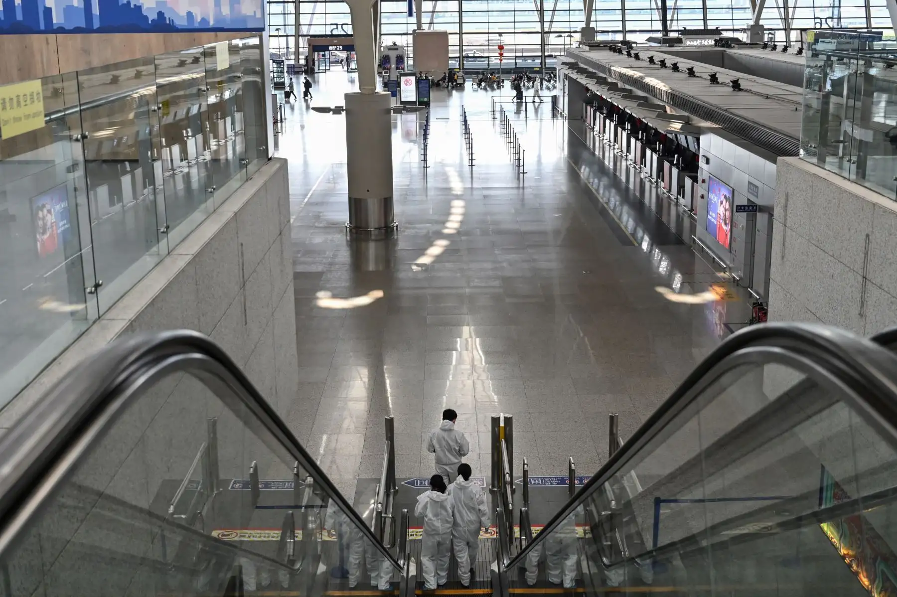 Trabajadores del aeropuerto con equipo de protección, en medio de preocupaciones por el coronavirus COVID-19, caminan por el Aeropuerto Internacional Pudong de Shanghai en Shanghai, China. Foto: AFP