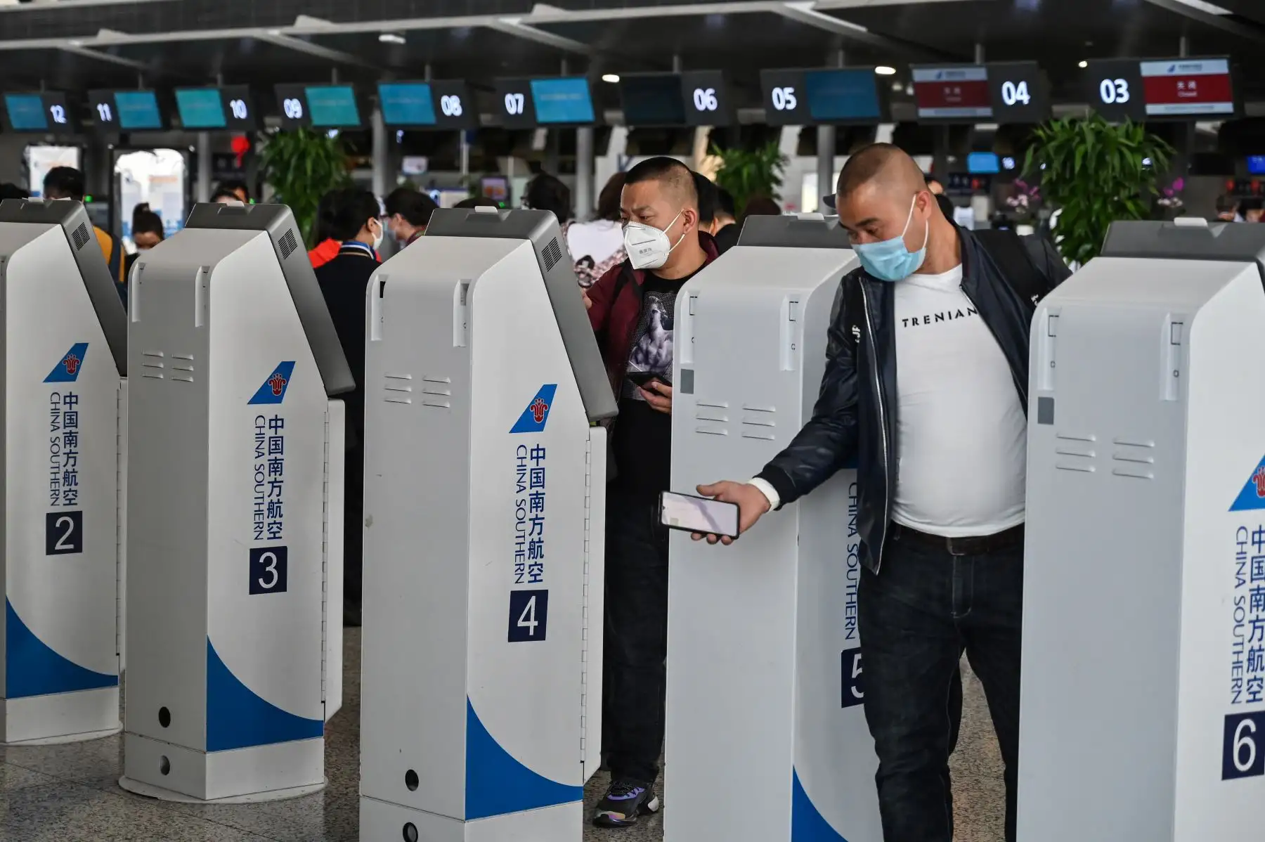 Los pasajeros que usan máscaras faciales, en medio de preocupaciones por el coronavirus COVID-19, caminan en el área del mostrador en el Aeropuerto Internacional Pudong de Shanghai en Shanghai, China. Foto: AFP