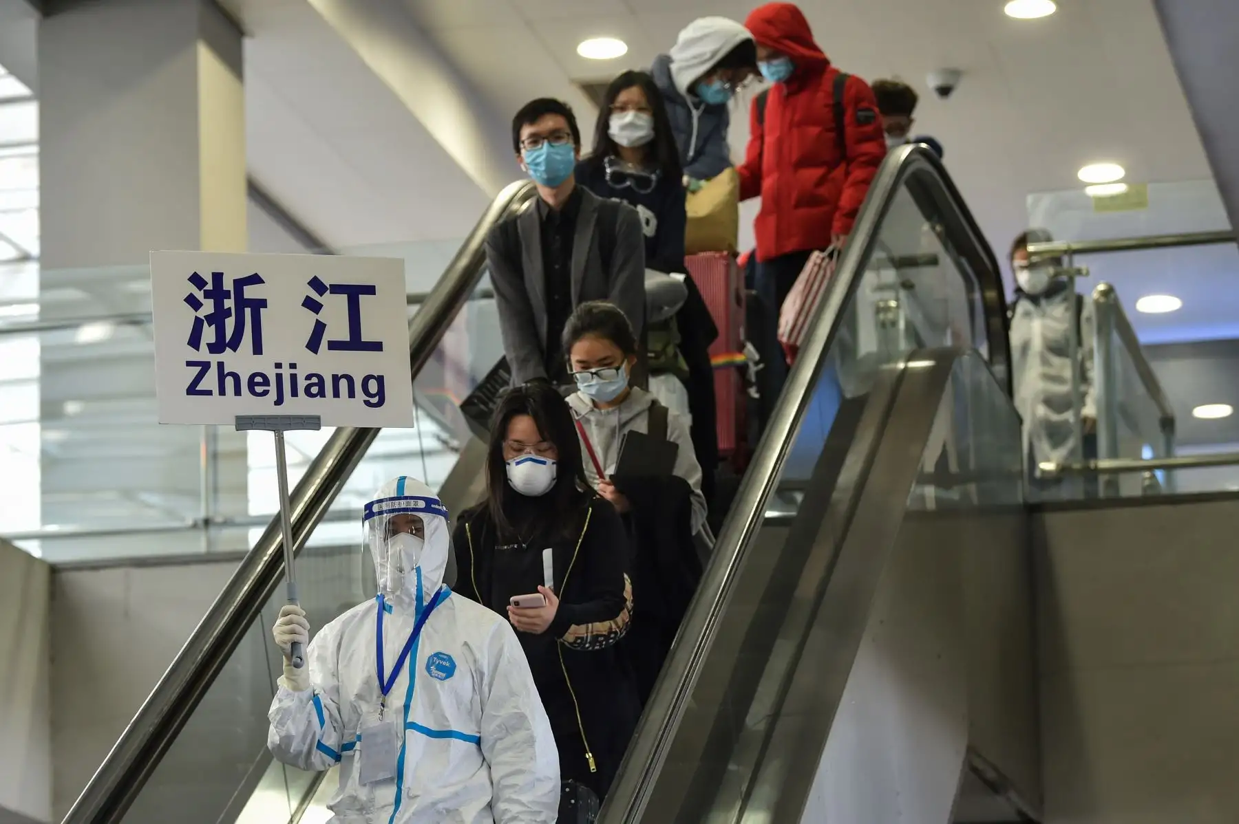 Los pasajeros que usan máscaras faciales, en medio de preocupaciones por el coronavirus COVID-19, caminan en el área del mostrador en el Aeropuerto Internacional Pudong de Shanghai en Shanghai, China. Foto: AFP