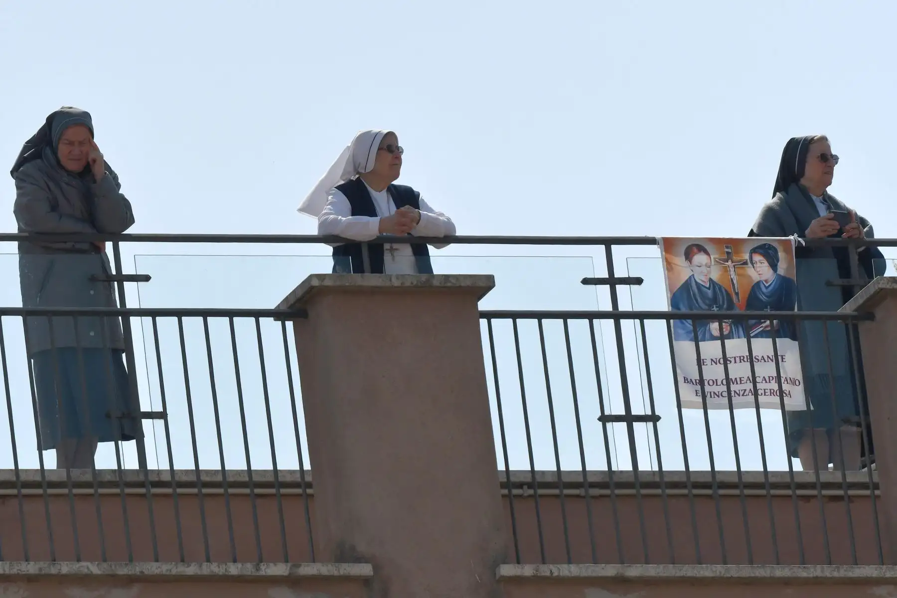 Las monjas esperan en un balcón para ver al Papa Francisco saludando desde la ventana del palacio apostólico con vistas a una plaza vacía de San Pedro después de su oración del Ángelus en el Vaticano.
Foto: AFP