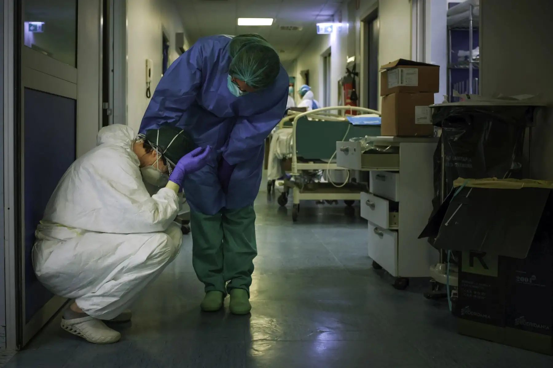 Una enfermera con máscara protectora y equipo conforta a otro mientras cambian de turno  en el hospital de Cremona, al sureste de Milán, Lombardía, durante el cierre del país destinado a detener la propagación del COVID-19. AFP