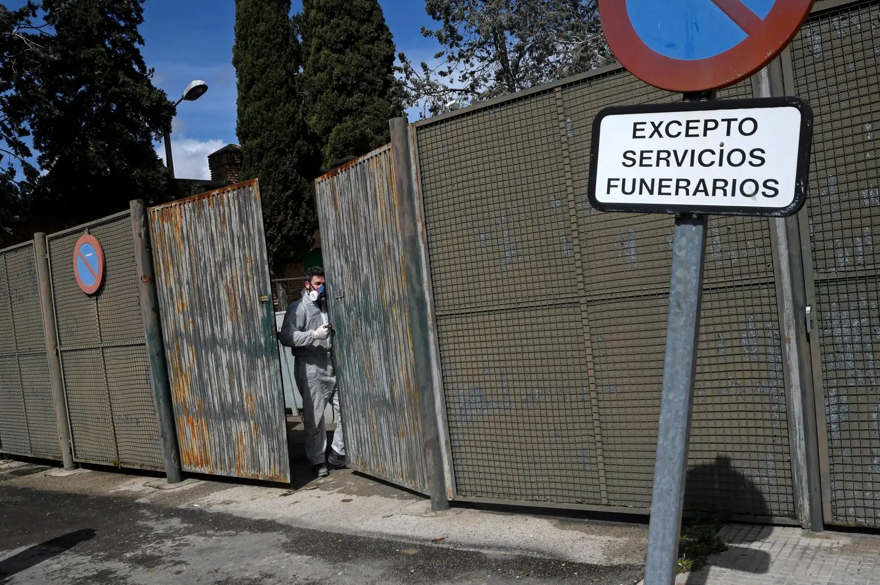 Un trabajador en un traje protector abre la puerta para un coche fúnebre que se acerca fuera del crematorio del cementerio de La Almudena en Madrid durante el funeral de una víctima del coronavirus COVID-19. España ha sido uno de los países más afectados, registrando el tercer mayor número de muertes con las últimas cifras que muestran un total de 2,696. Foto: AFP