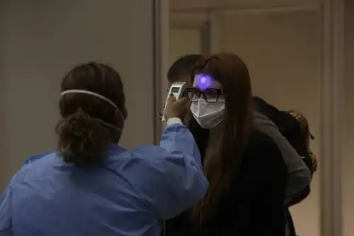 Profesionales de vigilancia sanitaria miden la temperatura a los pasajeros y tripulantes que desembarcan en el Aeropuerto Internacional de Galeão, en Río de Janeiro (Brasil). Foto: EFE
