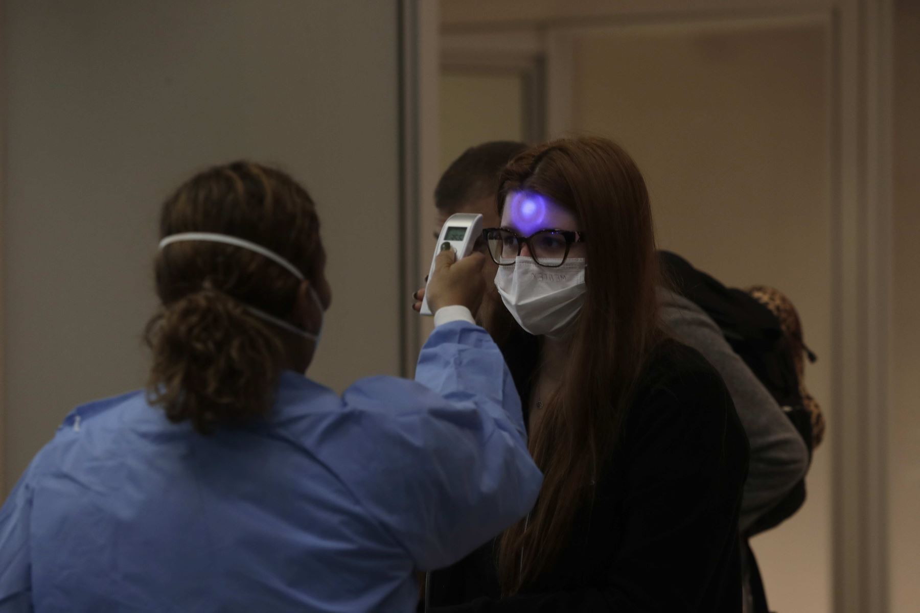 Profesionales de vigilancia sanitaria miden la temperatura a los pasajeros y tripulantes que desembarcan en el Aeropuerto Internacional de Galeão, en Río de Janeiro (Brasil). Foto: EFE