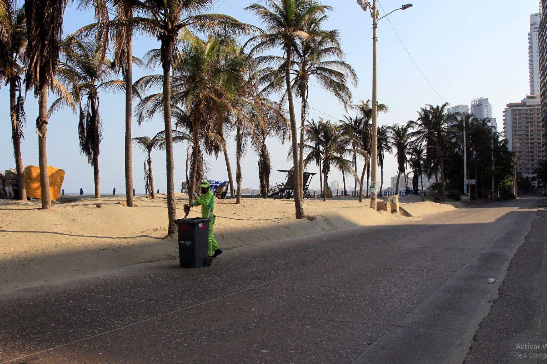 Un operario de limpieza trabaja en una calle solitaria en Cartagena de Indias. Colombia aplica restricciones de tránsito y aislamiento social para contener el coronavirus. Foto: EFE