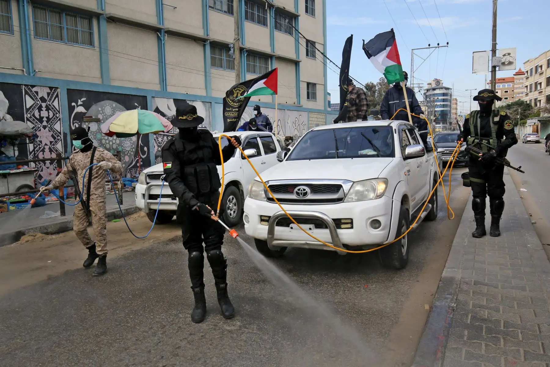 Miembros del ala armada de la Jihad Islámica Palestina, las Brigadas Al-Quds, rocían desinfectante en las calles de Rafah, en el sur de la Franja de Gaza durante una campaña destinada a frenar la propagación del nuevo coronavirus.
Foto: AFP