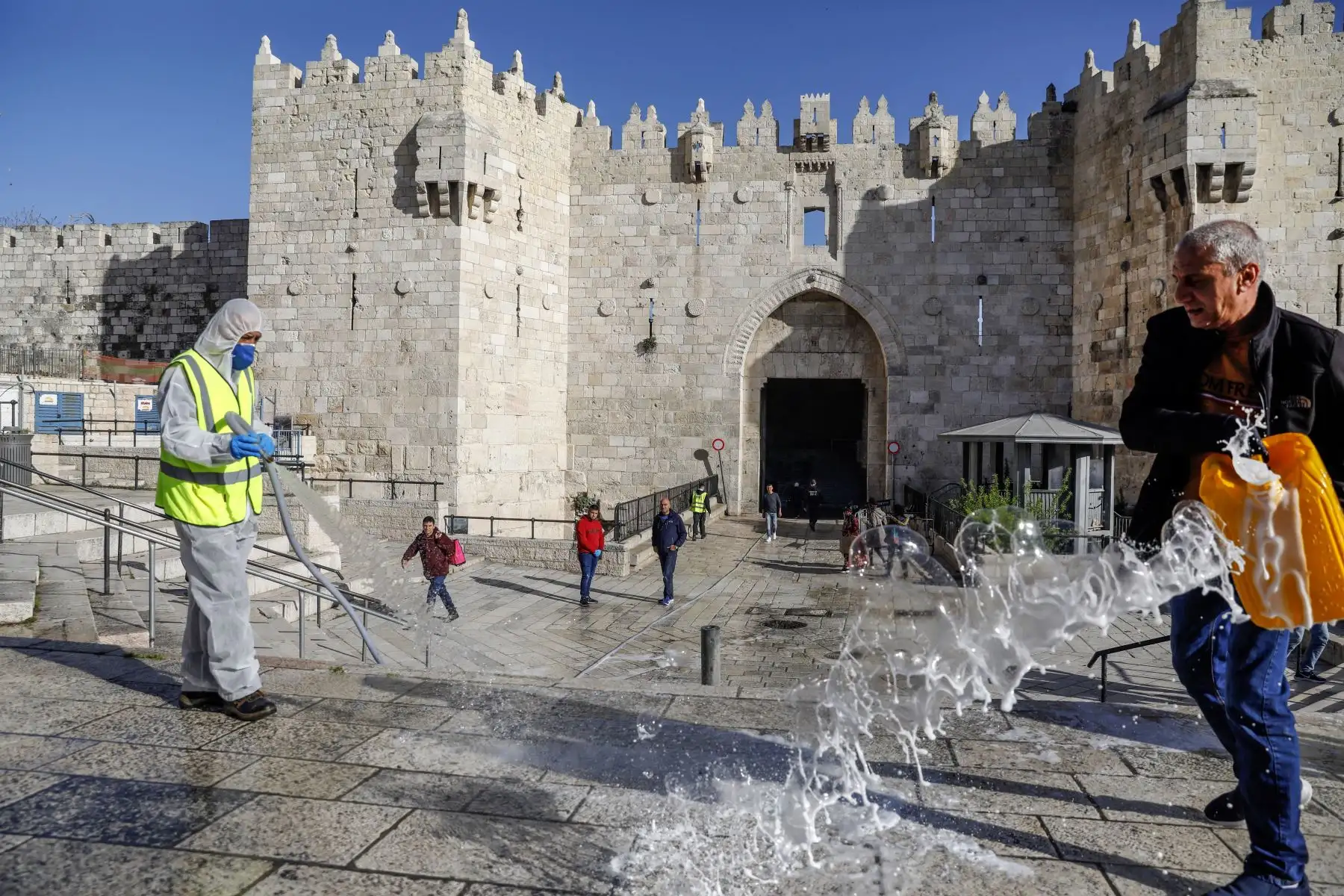 Los trabajadores municipales desinfectan frente a la Puerta de Damasco en la Ciudad Vieja de Jerusalén como medida contra la propagación del coronavirus.
Foto: AFP