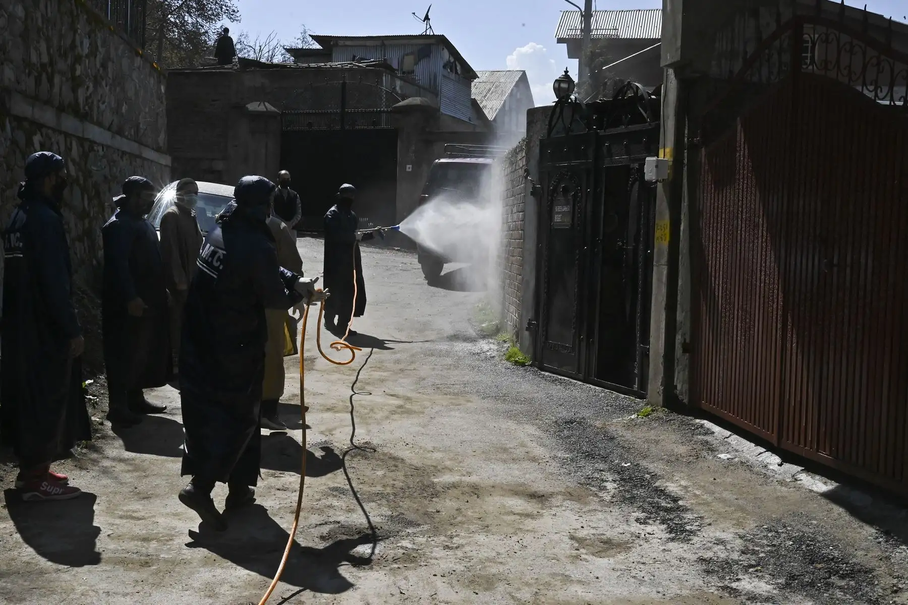 Los trabajadores municipales descontaminan y esterilizan un radio de trescientos metros alrededor de la casa de un residente que dio positivo por el coronavirus  en Srinagar.
Foto: AFP