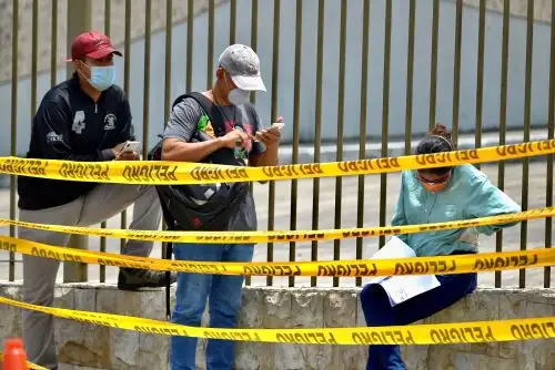 Familiares con tapabocas esperan este miércoles la llegada de los féretros con sus seres queridos a un cementerio de Guayaquil (Ecuador). Foto: EFE