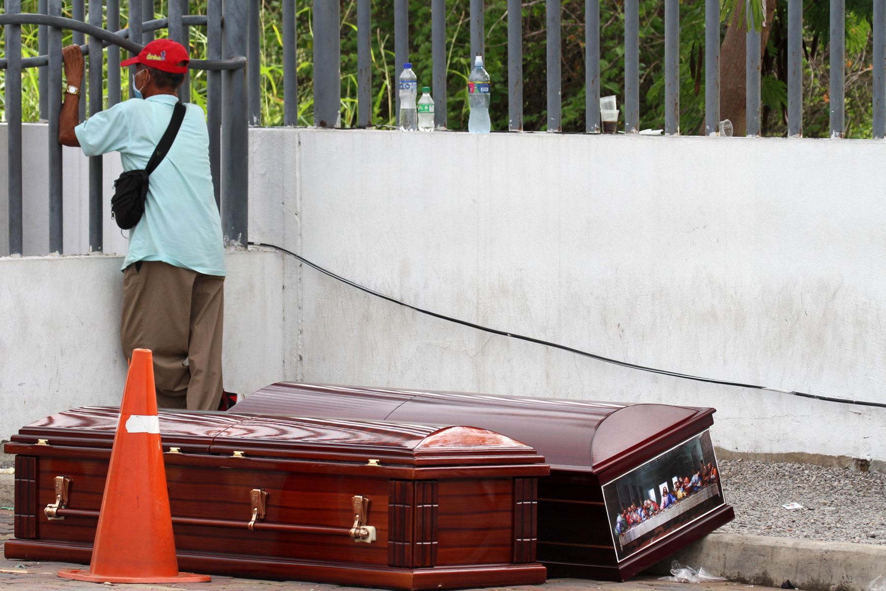 Hombre protegido con máscara facial espera el cadáver de un pariente frente a un hospital en Guayaquil, Ecuador. Foto: AFP