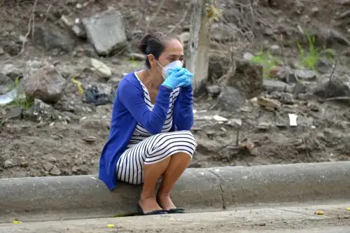Una mujer con una máscara facial contra la propagación del nuevo coronavirus espera noticias sobre un pariente frente a un hospital en Guayaquil, Ecuador. Foto: AFP