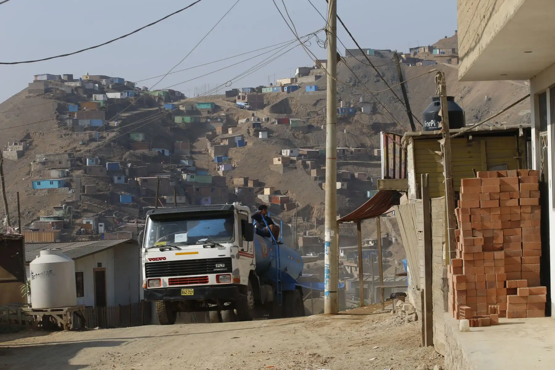 La llegada del aguatero a la agrupación familiar Chalwani en Santa Rosa de Puente Piedra es parte importante de la rutina en esta zona. El abastecimiento constante es indispensable para mantener medidas de limpieza necesarias contra el coronavirus Foto: ANDINA/Eddy Ramos