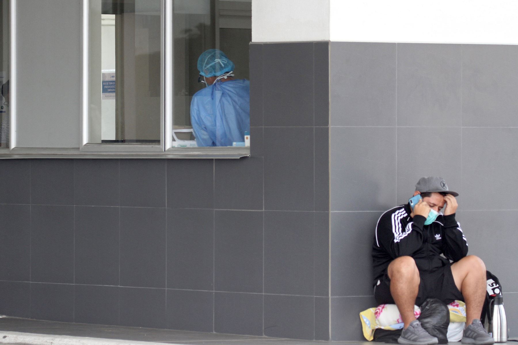 Un hombre habla en su teléfono móvil en el Hospital Los Ceibos en Guayaquil, Ecuador, durante la nueva pandemia de coronavirus. Foto: AFP