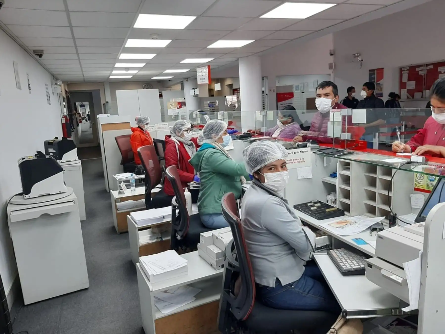 Trabajadores del Banco de la Nación, que atienden de manera personal al público, usan mascarillas de protección. Foto: Difusión