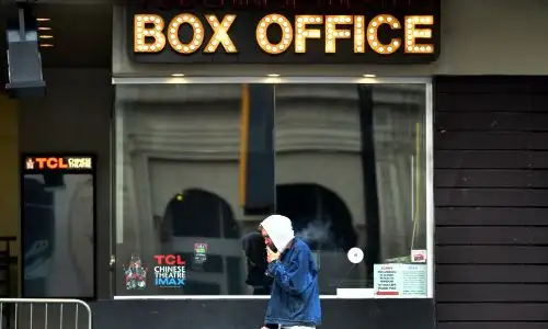Un hombre pasa frente a una taquilla cerrada a lo largo de Hollywood Boulevard en Estados Unidos. Foto:AFP